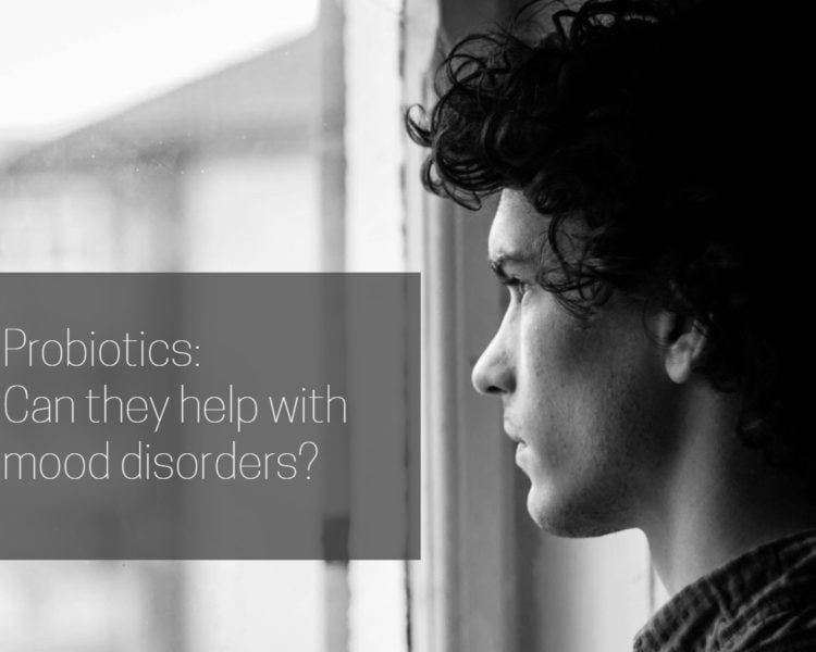Cover image for article on probiotics and moo disorders with a young man looking out a window in black and white