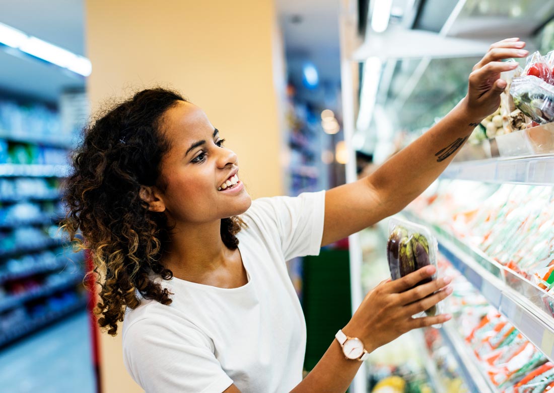 Image of a woman shopping at a grocery store for DASH diet and Mediterranean diet food