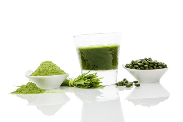 Image of different forms of chlorella supplements on a white reflective surface